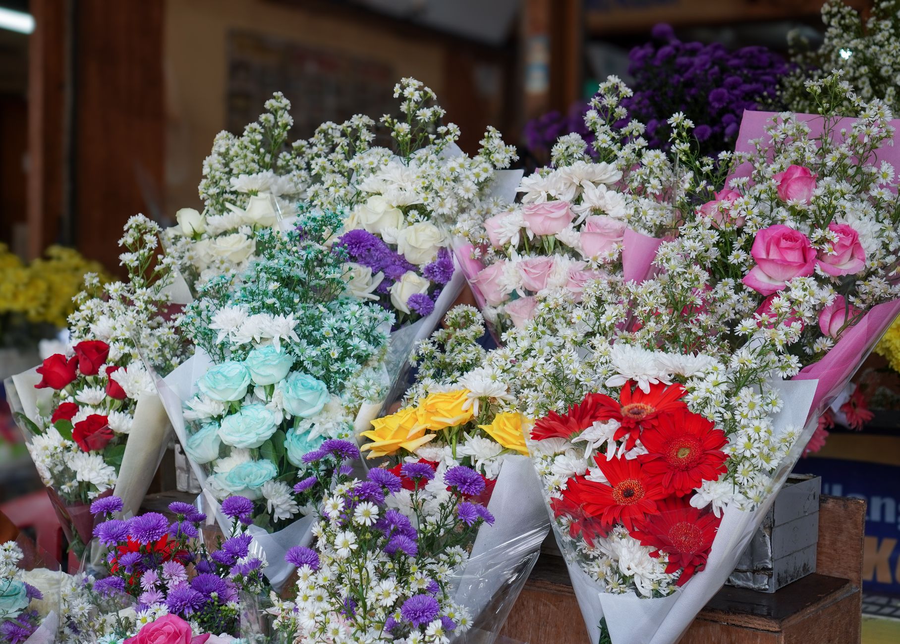 Kleurrijke boeketten met rozen en margrieten in onze bloemenwinkel
